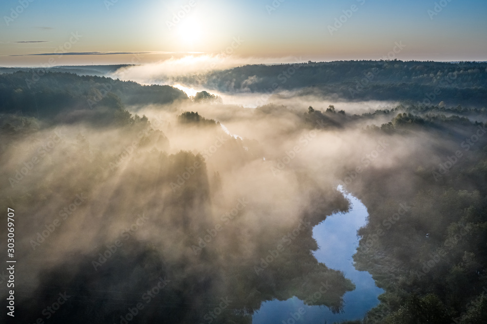 Fototapeta premium Wonderful mist over river in sunrise in autumn, aerial view