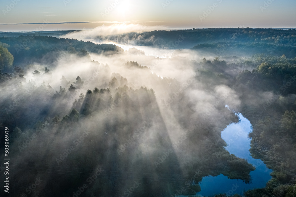 Wonderful fog over river with rays in autumn, aerial view