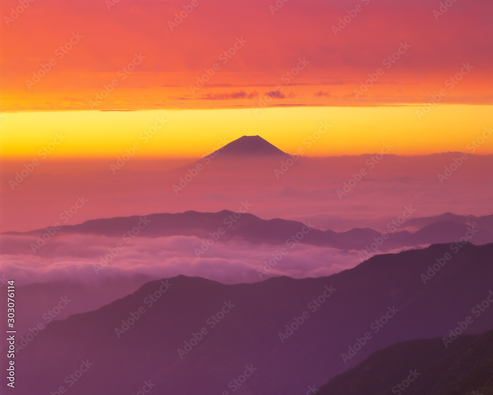 Obraz premium 北岳山頂から望む朝焼けに染まる天空の狭間（雲海と厚い雲）の富士山