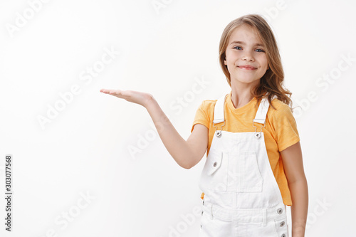 Foto Cheerful proud cute little girl showing achievement, introduce cool copy space,