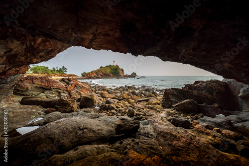 The picture taken from small cave at Ko Lanta in Krabi that can see Lighthouse Koh Lanta very small.