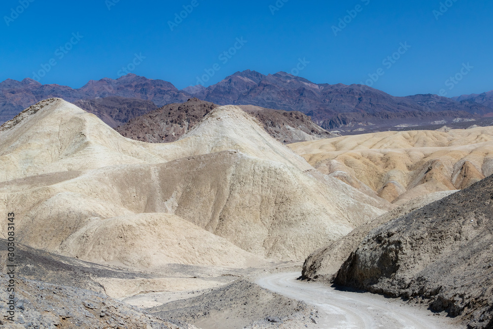 Fototapeta premium White rock formations etched against a clear blue sky in Death Valley National Park in California, USA
