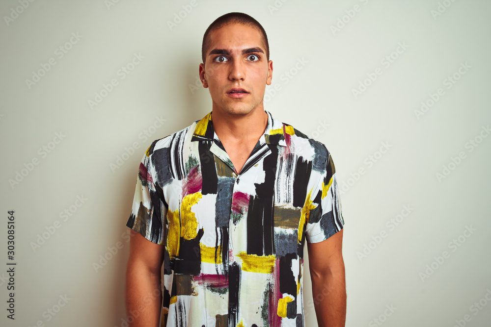 Young handsome man wearing summer shirt over white isolated background afraid and shocked with surprise expression, fear and excited face. Young handsome man wearing summer shirt over white isolated background afraid and shocked with surprise expression, fear and excited face.