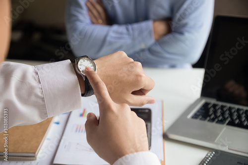 Businessman angry and pointing his smart watch as concept of arrive late at the work.