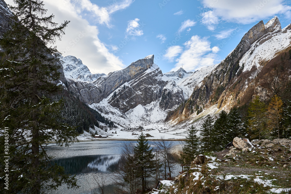Seealpsee im Appenzellerland mit Rossmad und Säntis, Spiegelung im See, Berglandschaft leicht mit Schnee bedeckt, Tannen, blauer Himmel mit Wolken Seealpsee im Appenzellerland mit Rossmad und Säntis, Spiegelung im See, Berglandschaft leicht mit Schnee bedeckt, Tannen, blauer Himmel mit Wolken