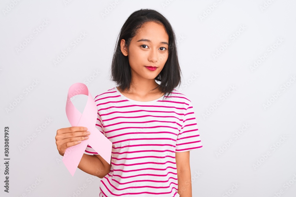 Young beautiful chinese woman holding cancer ribbon over isolated white background with a confident expression on smart face thinking serious Young beautiful chinese woman holding cancer ribbon over isolated white background with a confident expression on smart face thinking serious