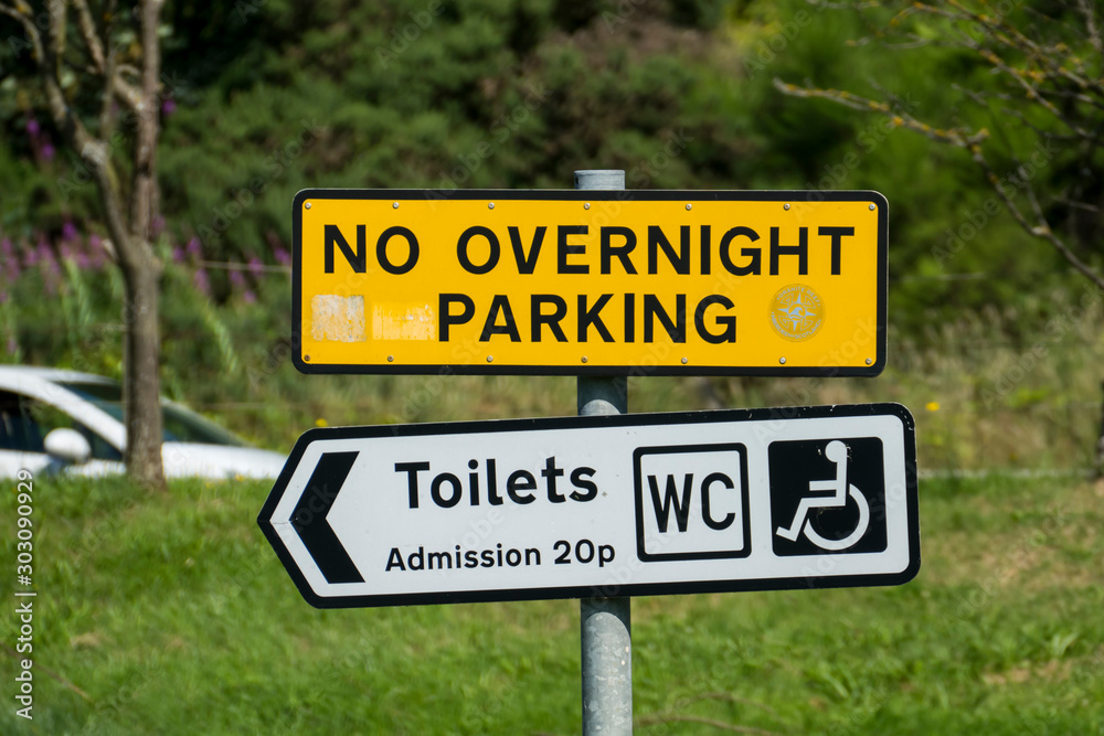 Schild auf einem öffentlichen Parkplatz mit dem englischen Text No overnight Parking, Toilets, Admission 20p, WC