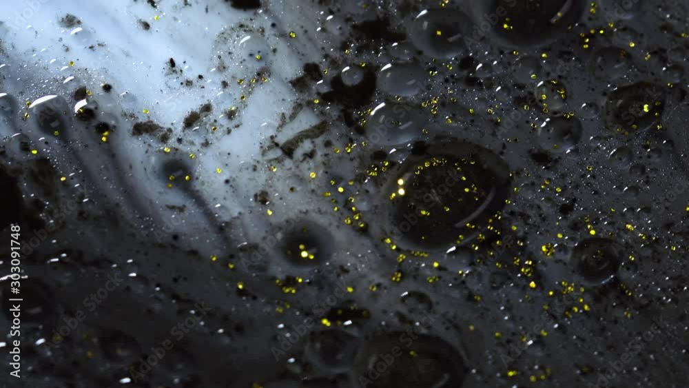 Beautiful colorful background with glitter and colored bubbles in oil and watercolor. Golden sparkle particles.  Macro oil ink bubbles and drops. Chroma galaxies magic fluids.Wallpaper pattern of gold