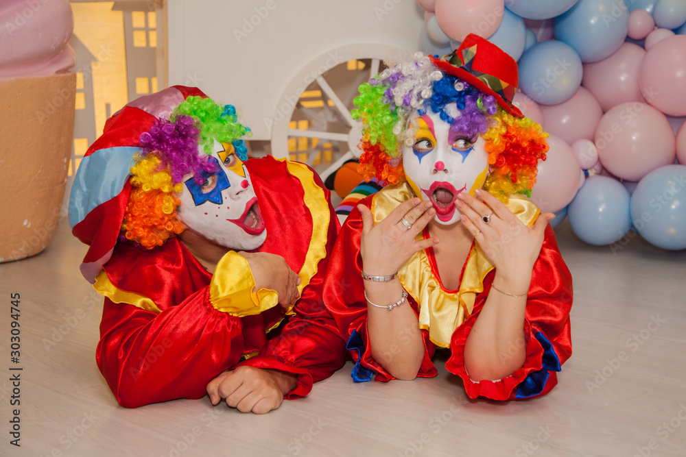 Funny clowns from the circus. Clown boy and clown girl show emotions Funny clowns from the circus. Clown boy and clown girl show emotions