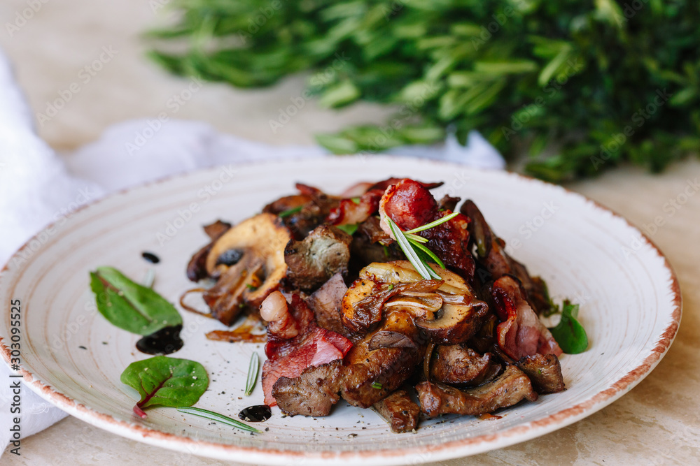 fried meat with mushrooms and bacon