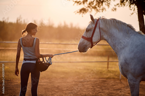 Canvas Print Lovely woman leading her horse