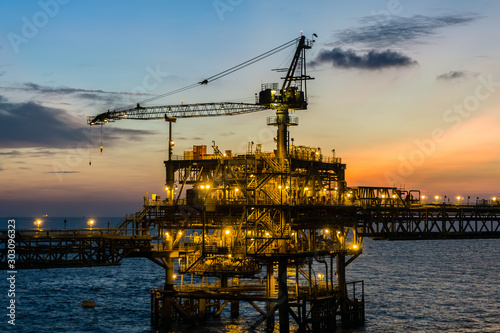 Silhouette of oil production platform during sunset photo