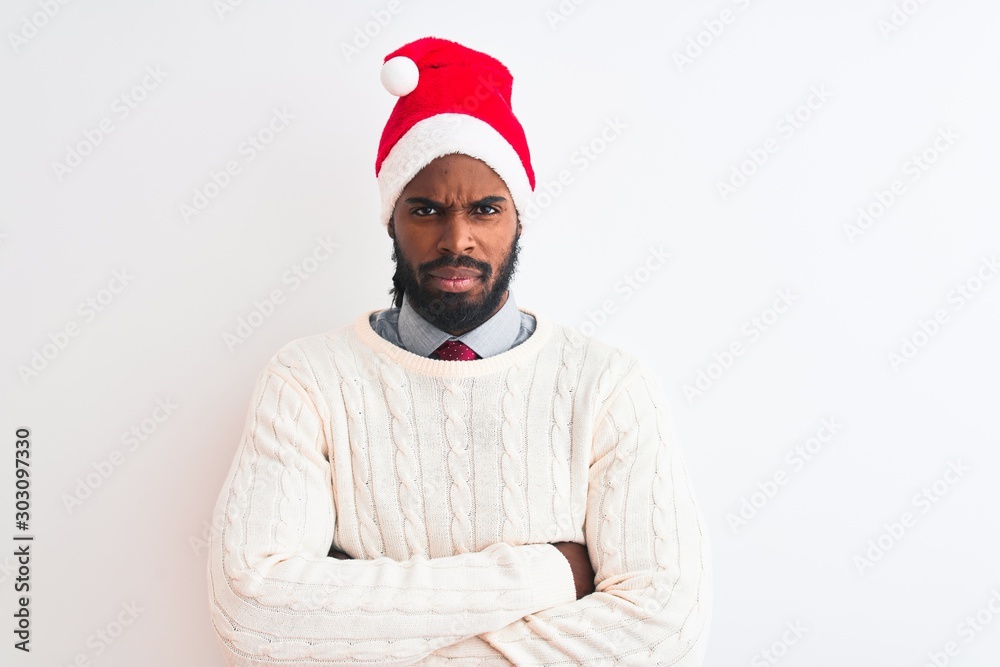 Young african american man wearing Christmas Santa hat over isolated white background skeptic and nervous, disapproving expression on face with crossed arms. Negative person.