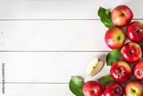 Fresh red apples on white background top view. Green apple leaves and fruits copy space. photo