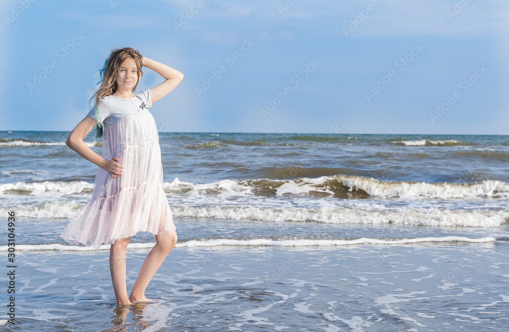 Adorable girl dancing by the sea