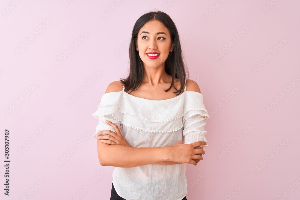 Beautiful chinese woman wearing white t-shirt standing over isolated pink background smiling looking to the side and staring away thinking. Beautiful chinese woman wearing white t-shirt standing over isolated pink background smiling looking to the side and staring away thinking.