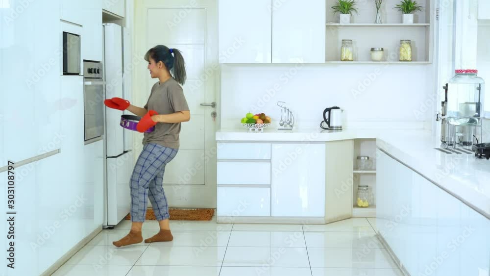 Happy young woman baking cake and dancing in the kitchen at home. Shot in 4k resolution Happy young woman baking cake and dancing in the kitchen at home. Shot in 4k resolution