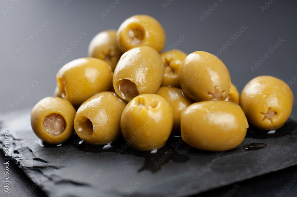 several olives lie on a black board on a black background macro super macro several olives lie on a black board on a black background macro super macro