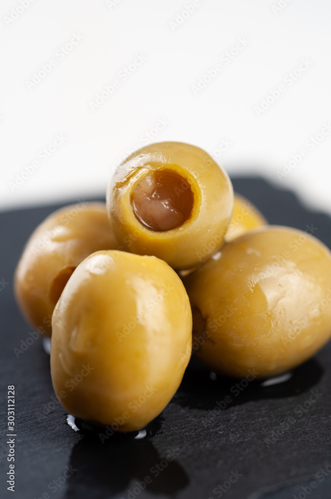 several olives lie on a black board on a white background macro super macro several olives lie on a black board on a white background macro super macro