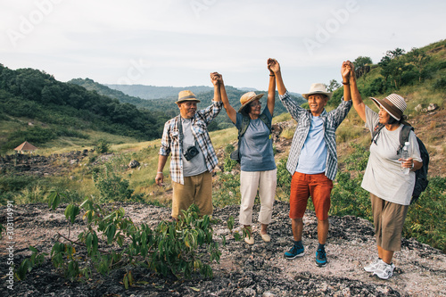 Obraz na plátně Group of elderly Asian lovers sit and relax on the foothills after they have climbed and adventure to this place