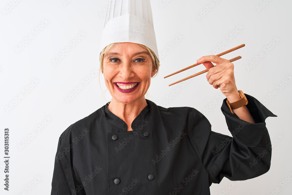 Middle age chef woman wearing cap holding chopsticks over isolated white background with a happy face standing and smiling with a confident smile showing teeth Middle age chef woman wearing cap holding chopsticks over isolated white background with a happy face standing and smiling with a confident smile showing teeth