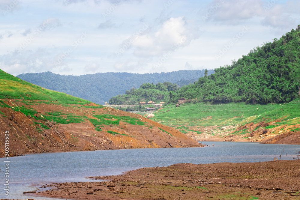 Along the river, there are arid lands surrounded by mountains and green trees from the water during the rainy season. Watersheds used in farming and farming.