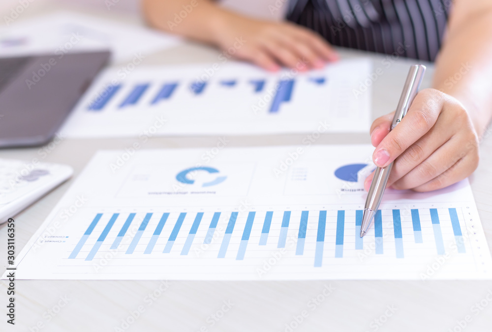 Business financial and investment concepts, people using calculators and data graphs to analyze company revenue and expenditures in preparation for the planning of presentations, finances concept Business financial and investment concepts, people using calculators and data graphs to analyze company revenue and expenditures in preparation for the planning of presentations, finances concept