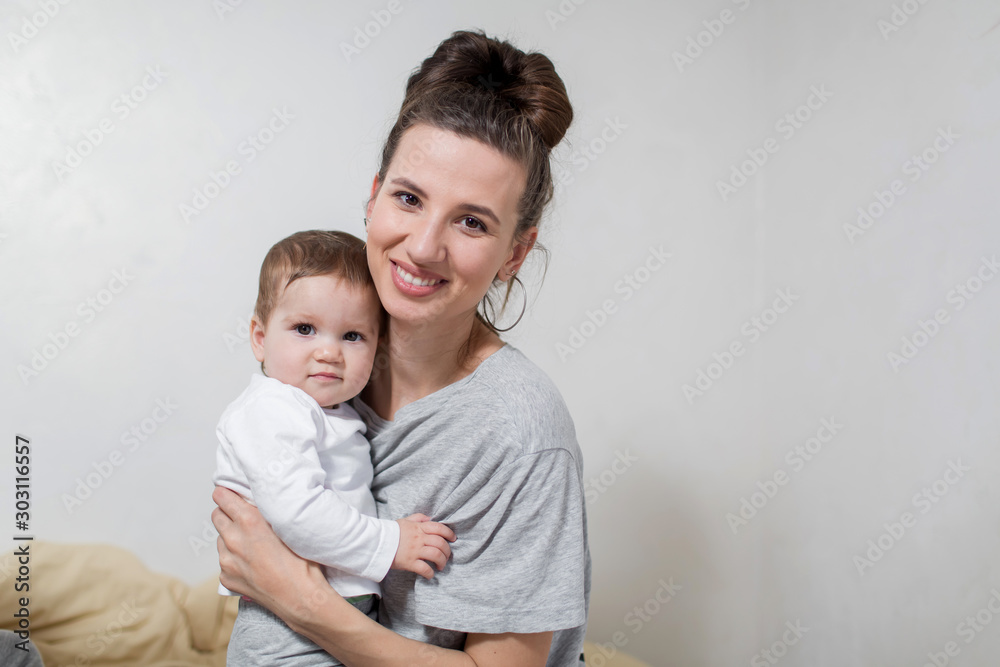 Happy mother and daughter hug each other on a couch.