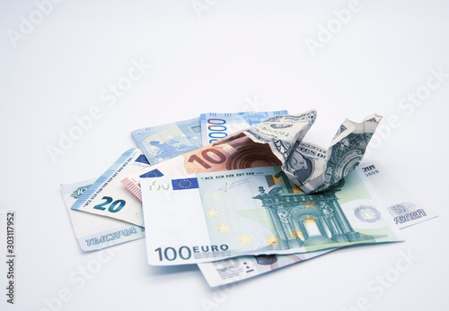 Money of different countries dollar, Euro, rubles and one crumpled dollar on top.