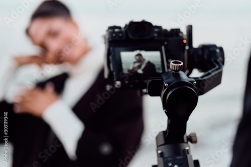 Attractive casual African American girl posing on camera during photo session by the sea