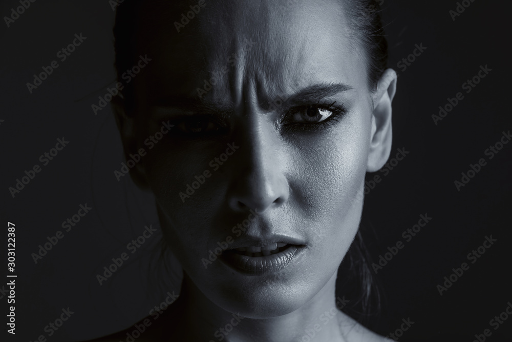 Black-white portrait of a girl close-up. Female emotions of disgust and discontent on her face. Black-white portrait of a girl close-up. Female emotions of disgust and discontent on her face.