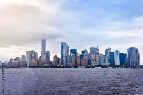 Cityscape of the financial district of Manhattan from Liberty Island, in a foggy day.