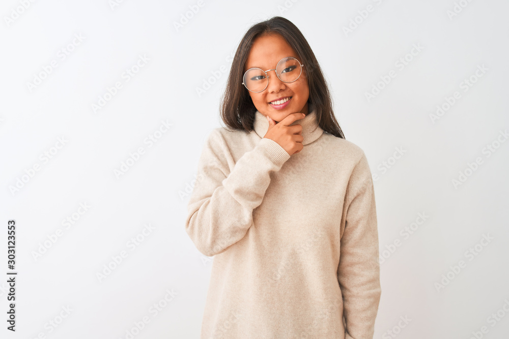 Young chinese woman wearing turtleneck sweater and glasses over isolated white background looking confident at the camera with smile with crossed arms and hand raised on chin. Thinking positive. Young chinese woman wearing turtleneck sweater and glasses over isolated white background looking confident at the camera with smile with crossed arms and hand raised on chin. Thinking positive.