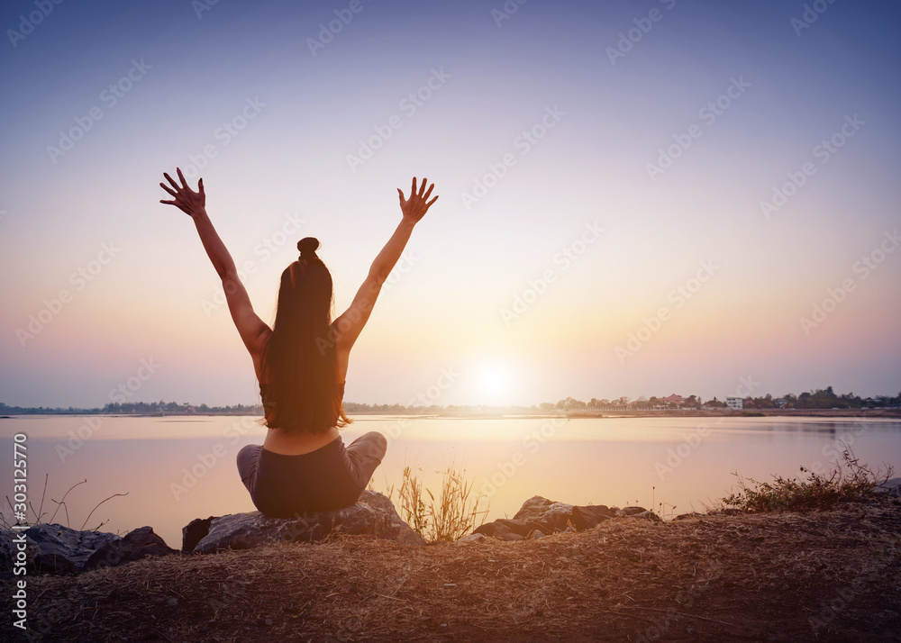 Young woman practicing yoga during sunset