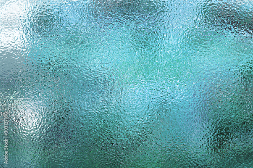 Light blue matte surface. Wet plastic glass. Frosted winter window glass