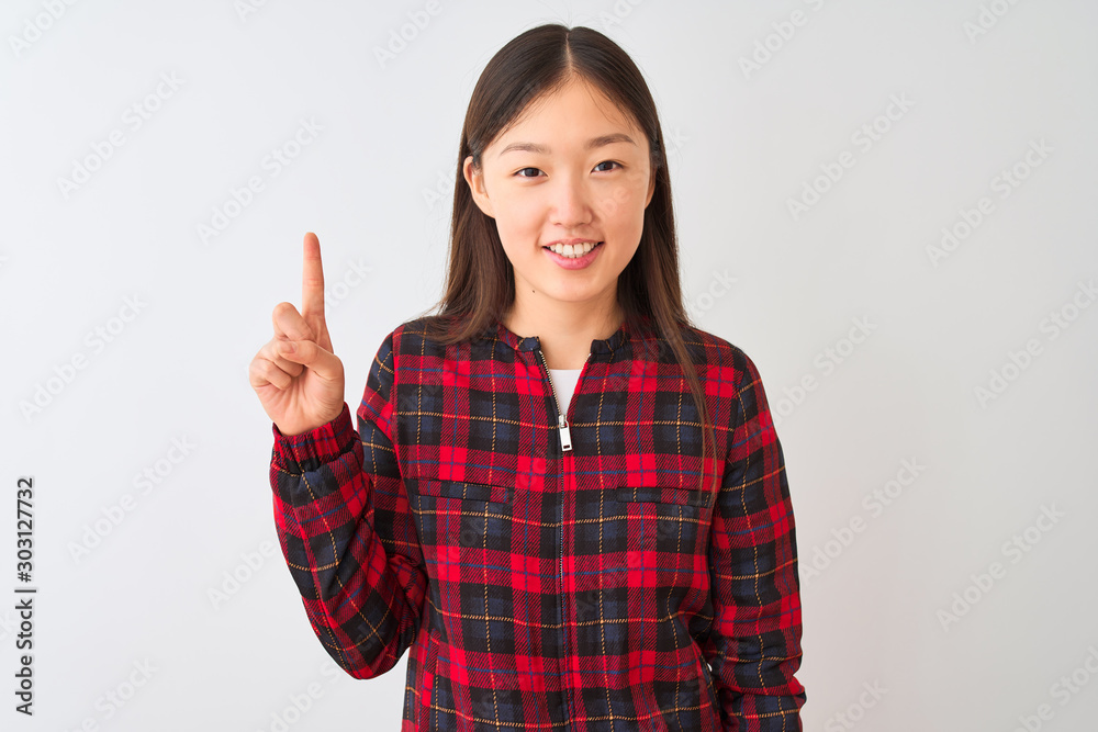 Young chinese woman wearing casual jacket standing over isolated white background showing and pointing up with finger number one while smiling confident and happy. Young chinese woman wearing casual jacket standing over isolated white background showing and pointing up with finger number one while smiling confident and happy.
