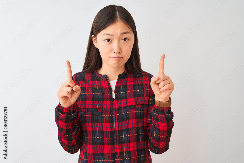 Young chinese woman wearing casual jacket standing over isolated white background Pointing up looking sad and upset, indicating direction with fingers, unhappy and depressed. Young chinese woman wearing casual jacket standing over isolated white background Pointing up looking sad and upset, indicating direction with fingers, unhappy and depressed.