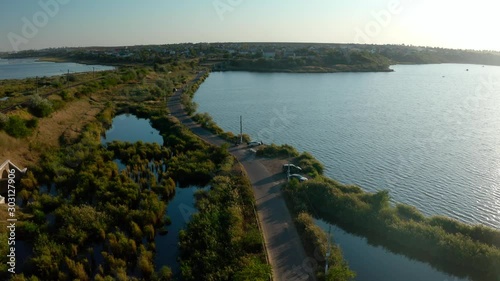 Drone camera flying towards over the coastline of the Sukhyi Lyman with small village on the right. Odessa, Ukraine, Septemberr 2019. photo