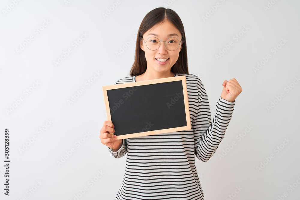 Young chinese woman wearing glasses holding blackboard over isolated white background screaming proud and celebrating victory and success very excited, cheering emotion Young chinese woman wearing glasses holding blackboard over isolated white background screaming proud and celebrating victory and success very excited, cheering emotion