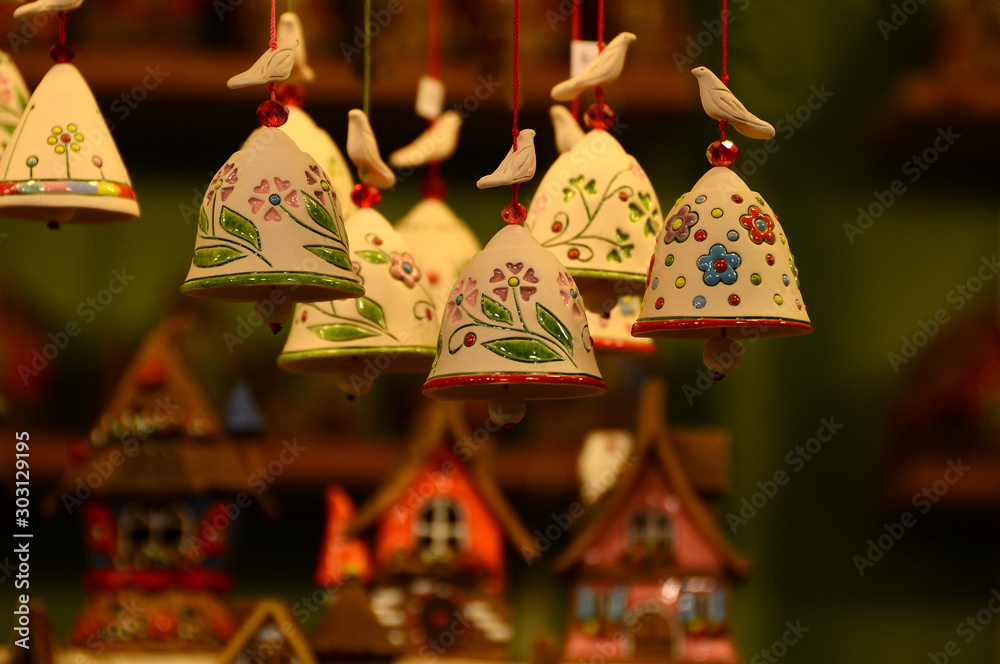 small decorated bells hanging from the roof in a Christmas market. Italy.