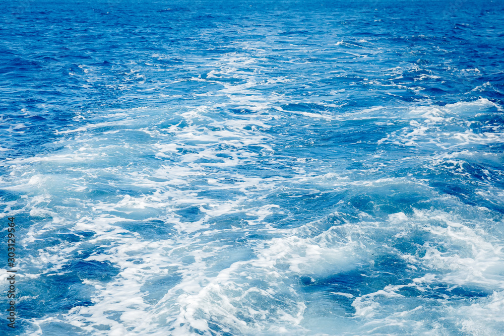 Obraz premium Blue sea surface background with splashing waves