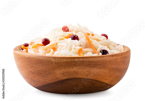 Sauerkraut with carrots and cranberries in a wooden plate on a white, isolated.