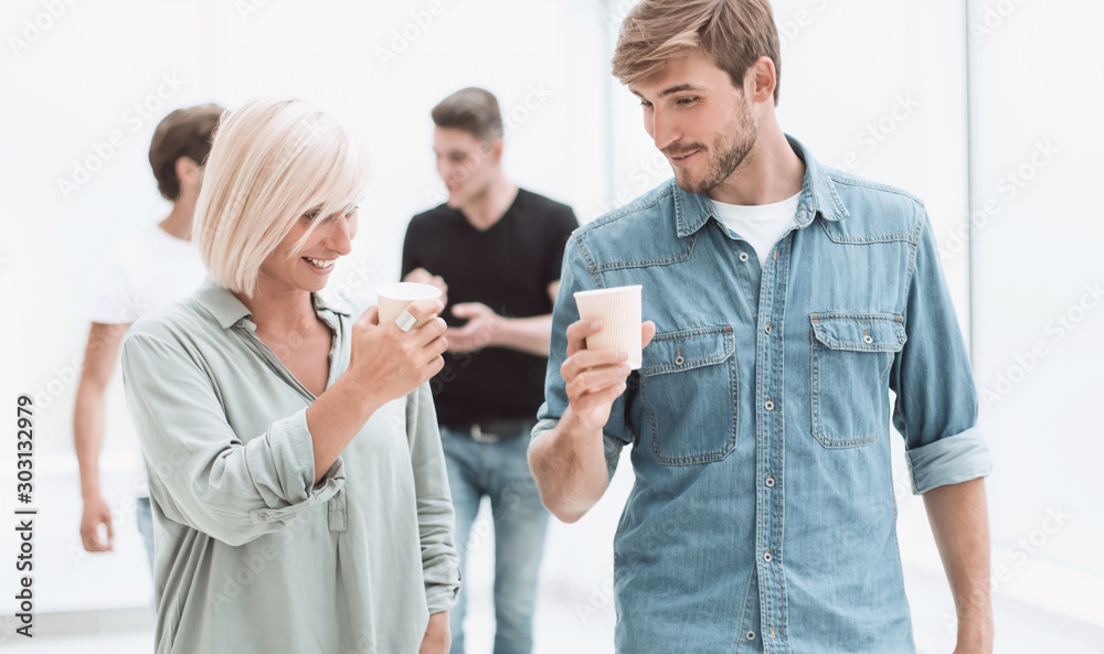 Fototapeta premium employees with coffee glasses passing through the corridor of the office