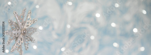 silver snowflake on blue xmas background with space for your text. Merry christmas.