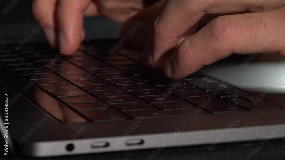 Person working on a Laptop with low-light Reflections, static close up Person working on a Laptop with low-light Reflections, static close up