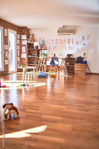 Picture of preschool playroom with colorful furniture and toys around empty kindergarten