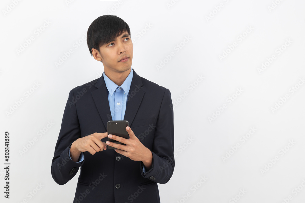 Young handsome asian business man playing smartphone and thinking isolated on white background. Young handsome asian business man playing smartphone and thinking isolated on white background.