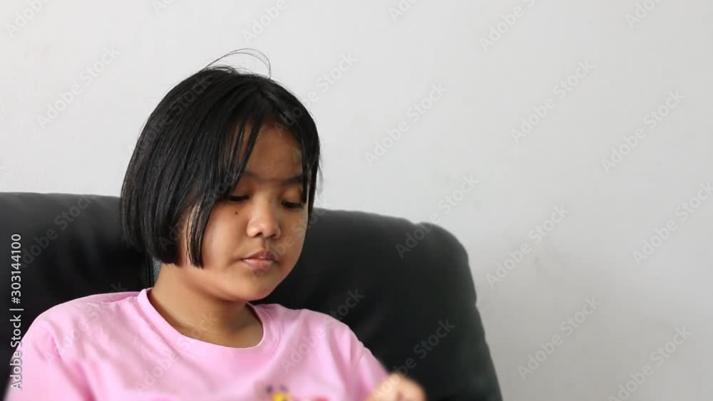 Portrait of Asian teenage to play mobile phone on the sofa in the living room Portrait of Asian teenage to play mobile phone on the sofa in the living room