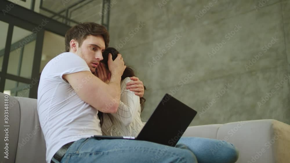 Portrait of scared couple watching laptop computer at home in slow motion. Portrait of scared couple watching laptop computer at home in slow motion.
