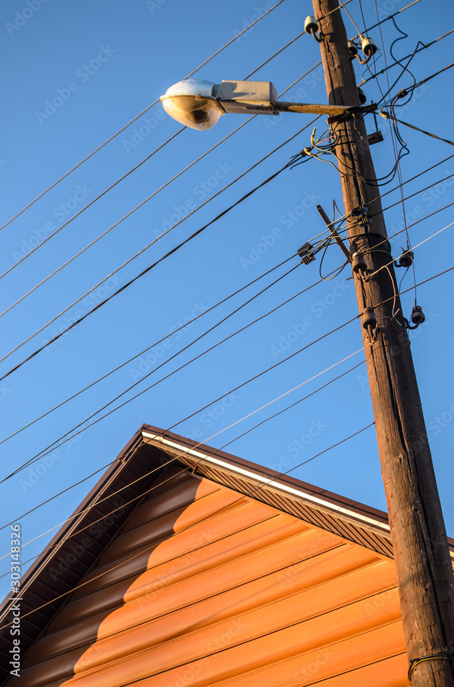 Conceptual photo of a house and wired electric lines near country houses Conceptual photo of a house and wired electric lines near country houses